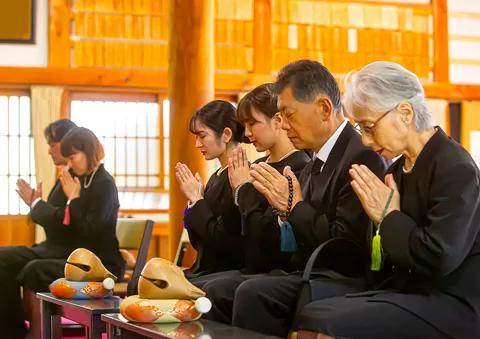 さいたま市家族葬で喪服の家族が寺院で手を合わせる葬儀 さいたま市